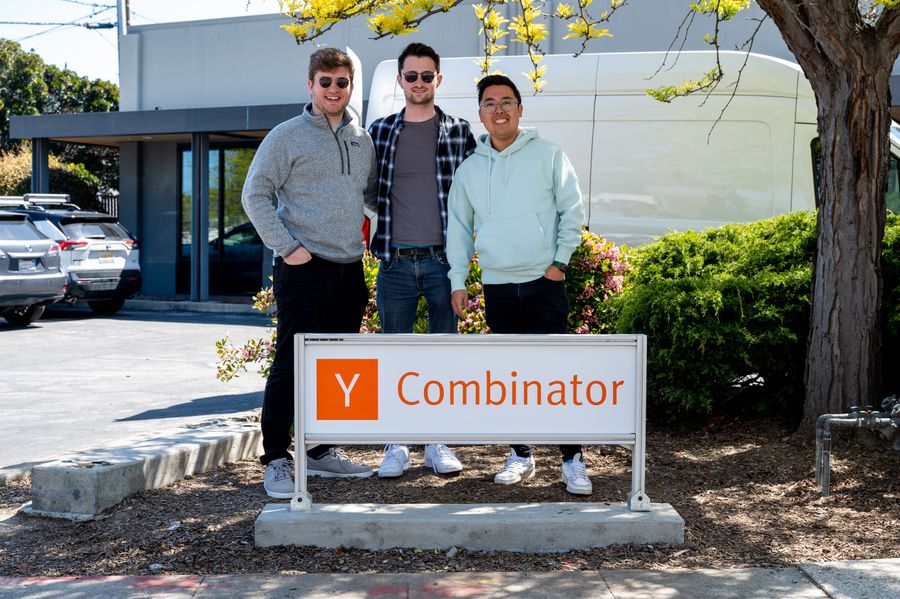 Alistair Pullen, Sam Stenner and Yang Li, stand behind the Y Combinator office sign in San Fransisco